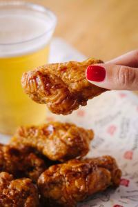 Bonchon chicken wings as shown in this image are are available in portions for any party size on any occasion and come with a complementary side of coleslaw or pickled radish.