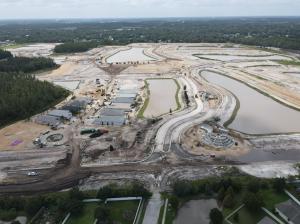 Aerial view of Misha and Itchko Ezratti's GL Homes construction at Valencia Ridge, featuring nine luxurious model homes nearing completion, surrounded by scenic lakes and infrastructure development. These homes, designed for the 55+ community, blend moder