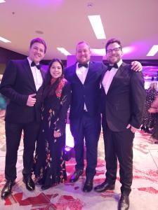 A group of people in black tie attire at a formal awards ceremony.