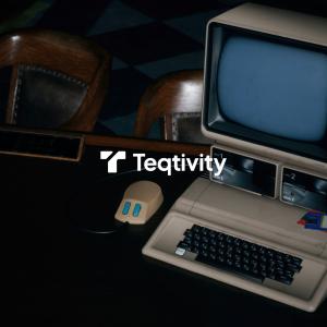 Vintage beige computer terminal and keyboard photographed in moody lighting, showcasing Teqtivity's focus on tracking IT assets and preventing equipment loss. The retro technology setup contrasts with modern asset management solutions.