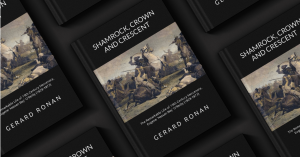 A display of multiple copies of the book Shamrock, Crown and Crescent by Gerard Ronan, featuring a cover illustration of a cavalry battle, highlighting the adventurous life of Eugene ‘Hassan Bey’ O’Reilly amidst 19th-century political and military turmoil